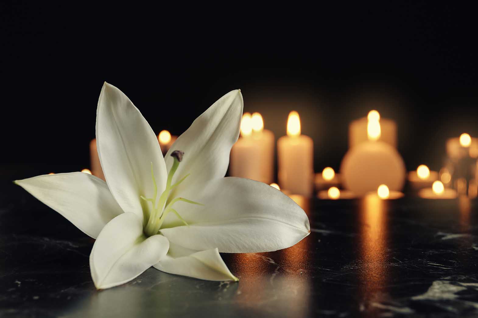 White Lily And Blurred Burning Candles On Table In Darkness, Spa: An Executor is appointed for the Estate